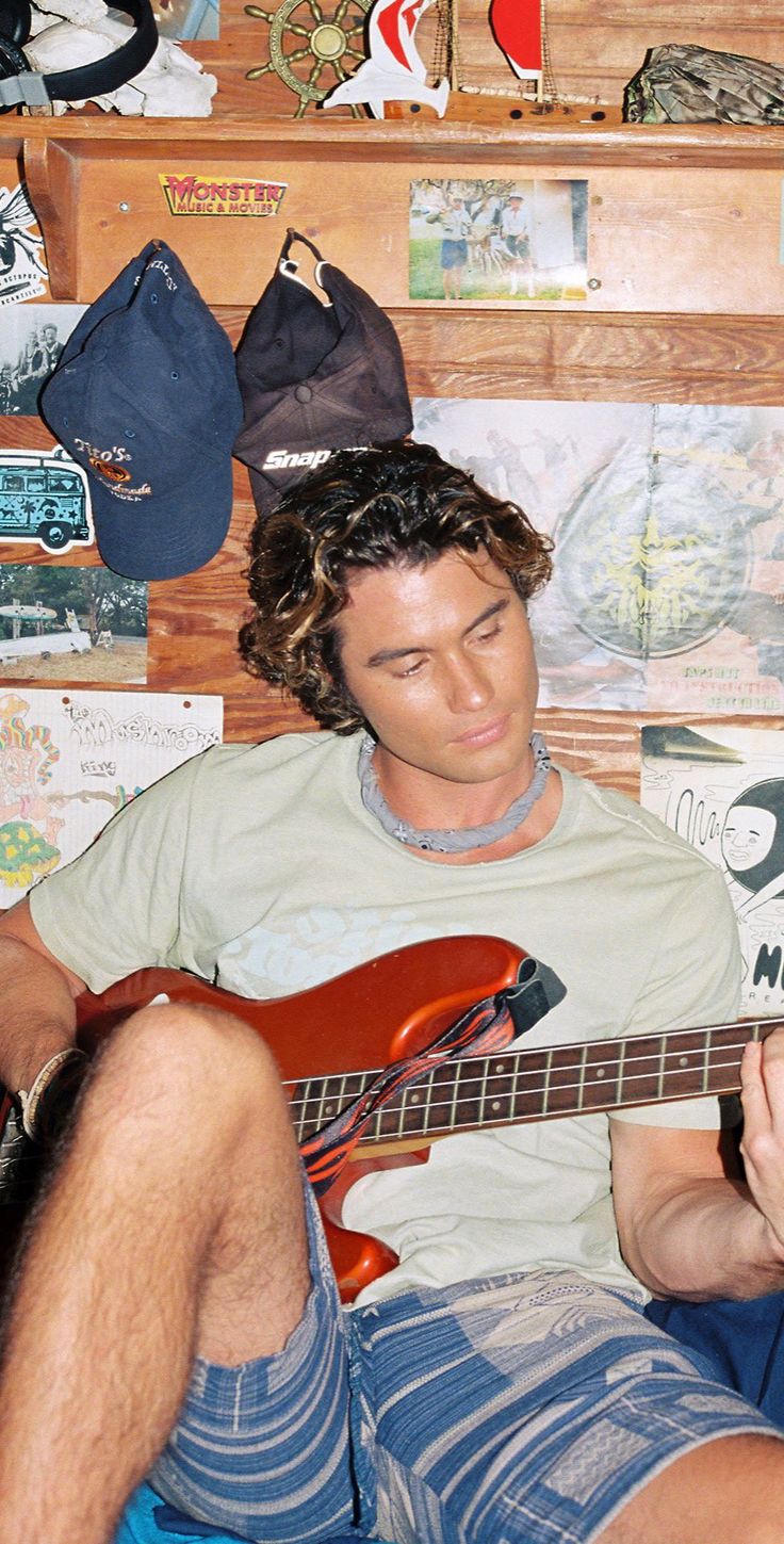 a man sitting on the floor playing an electric guitar