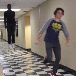 two young men are walking down the hallway in an office building with checkered flooring