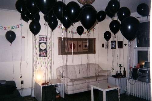 black balloons are hanging from the ceiling in a living room