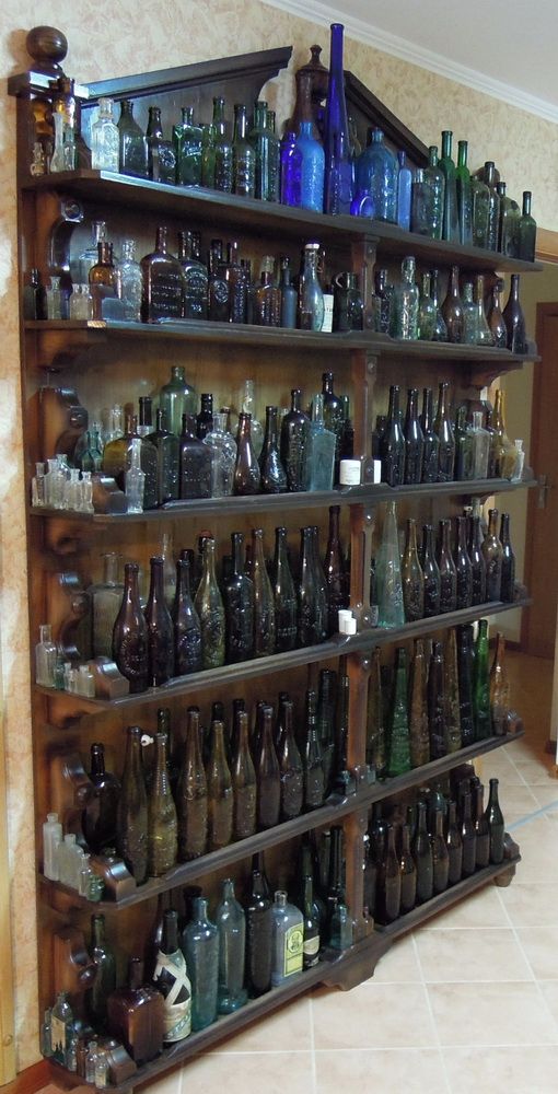 a shelf filled with lots of bottles on top of a tiled floor