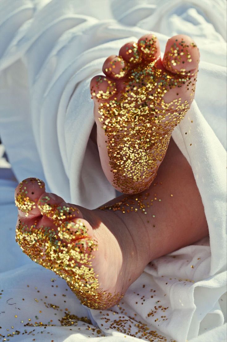 a person's feet covered in gold glitter