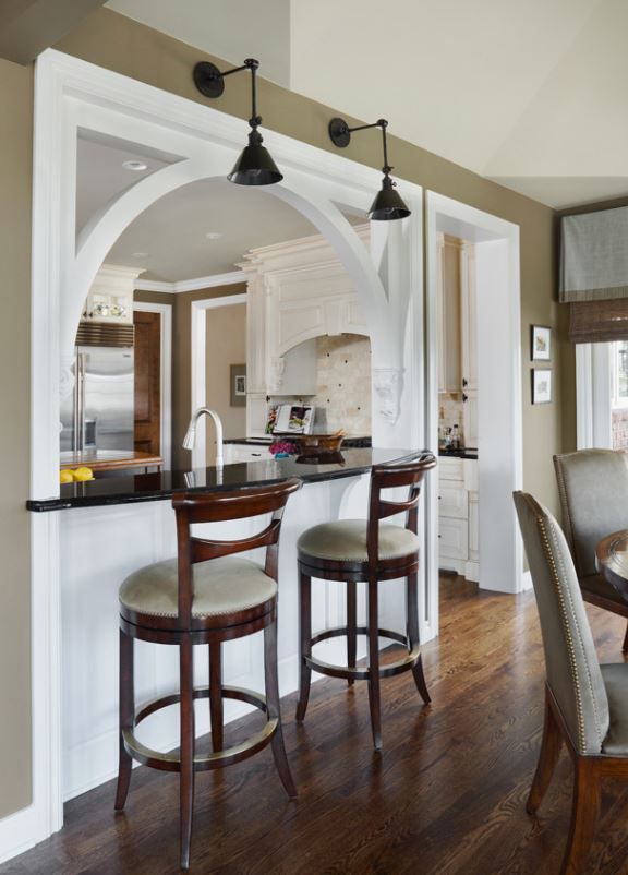 an open kitchen and dining room area with bar stools