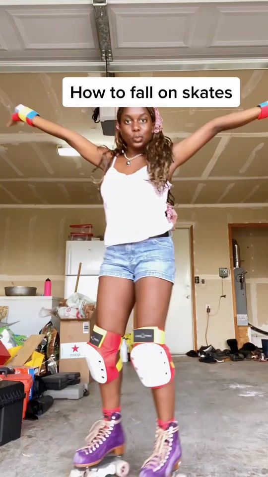 a girl with roller skates standing in a garage holding her arms out to the side