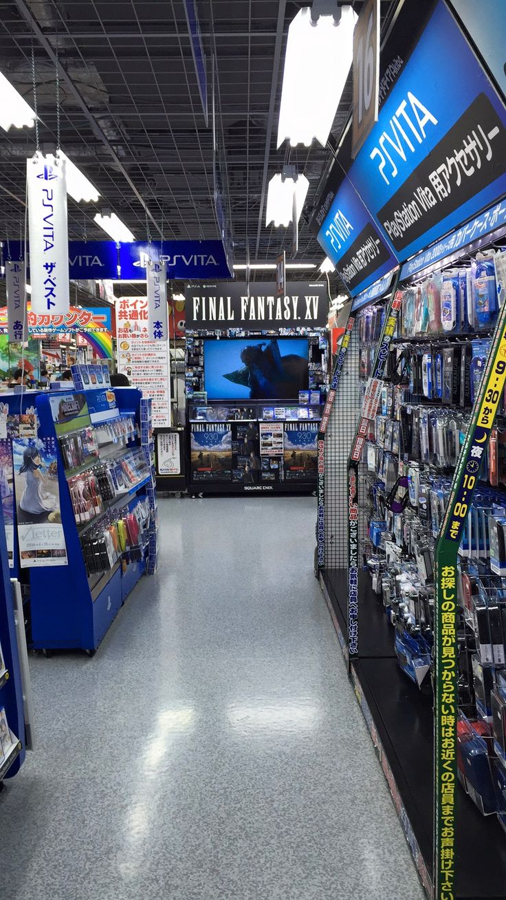 an aisle in a store filled with magazines and video game consoles on the wall behind them