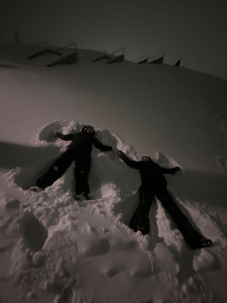 two people standing in the snow holding hands