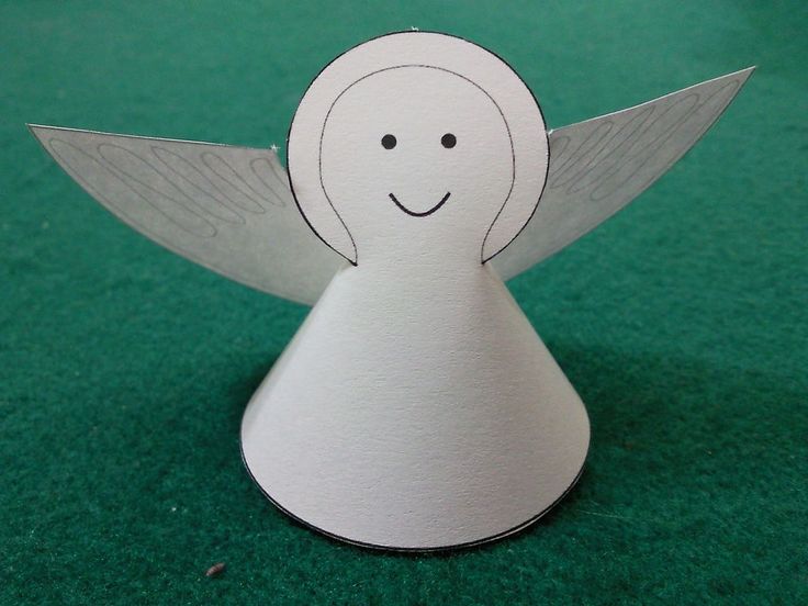 a white paper angel sitting on top of a green table