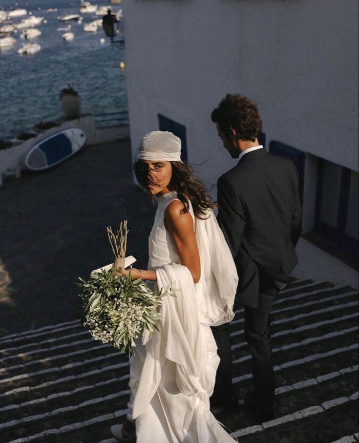 a woman in a white dress walking next to a man