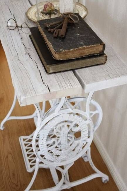 an old book is sitting on a small table with some scissors and a glass vase