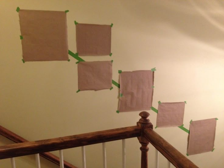 several pieces of paper taped to the wall above a banister with wooden handrails