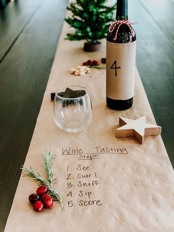 a table with wine bottle, glass and corkscrew next to it on top of paper