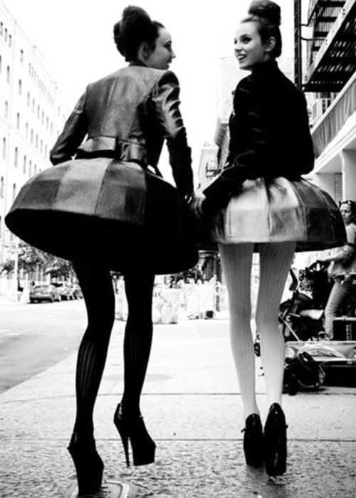 two women are walking down the street together