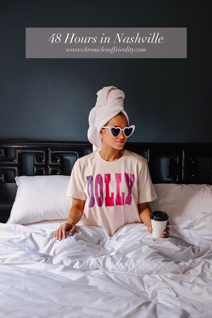 a woman sitting on top of a bed wearing sunglasses and a towel wrapped around her head