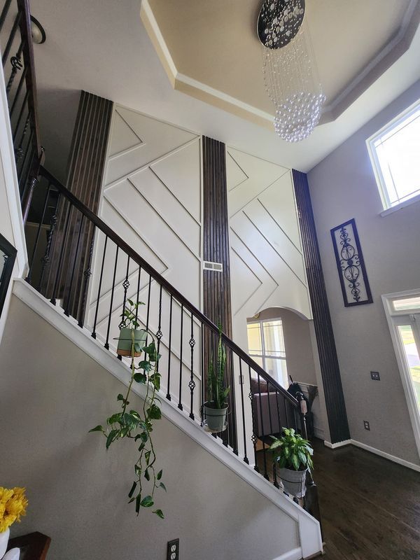 the stairs in this house are made of wood and have chandeliers hanging from them