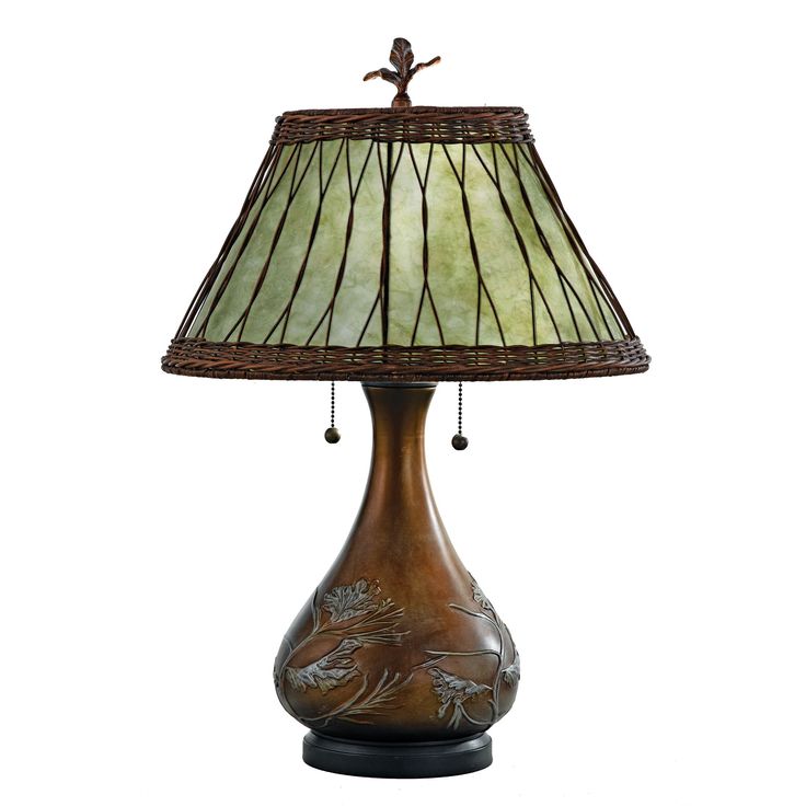 a lamp that is on top of a wooden base with a green shade over it