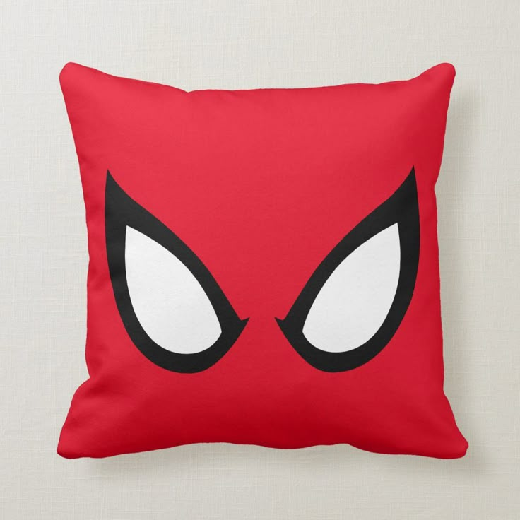 a red pillow with white eyes and black eyelashes on the front, which is part of a spider - man costume