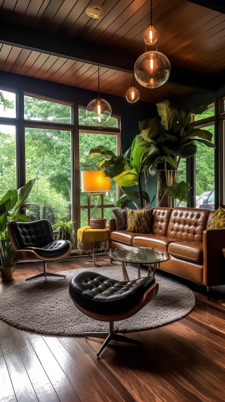 a living room filled with lots of furniture and large windows overlooking the trees in the forest