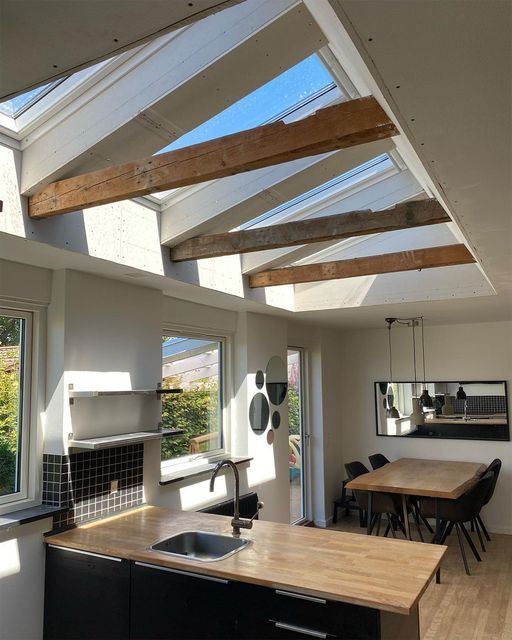 an open kitchen and dining room with skylights