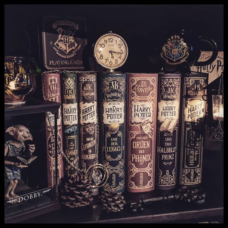 several harry potter books are stacked on top of each other in front of a clock