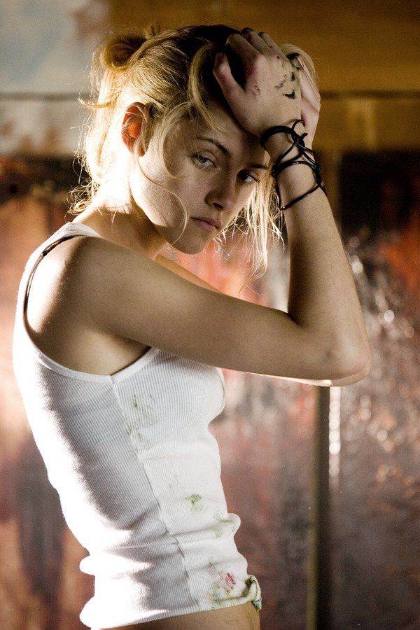 a woman in white shirt holding her hair