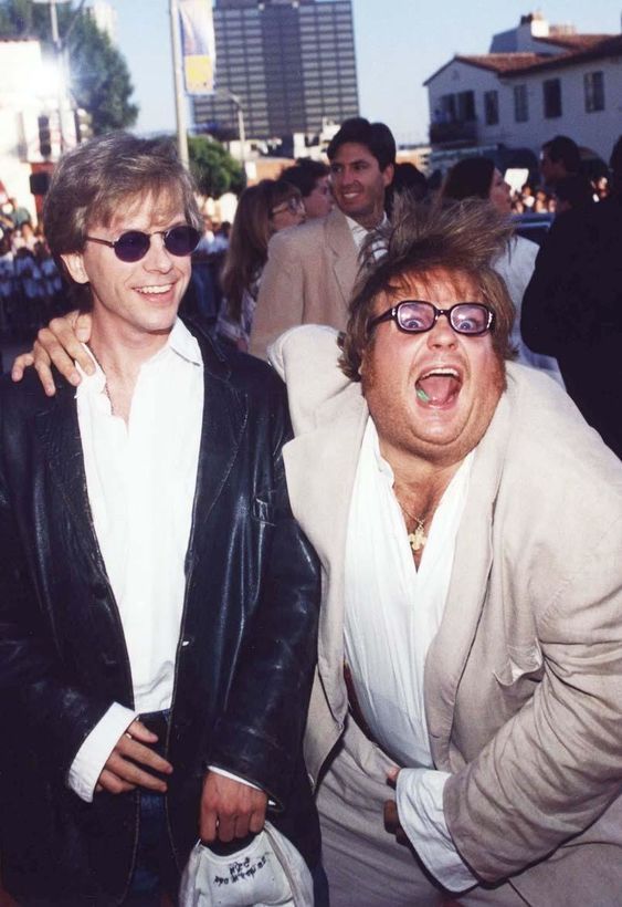 two men are posing for the camera in front of a crowd