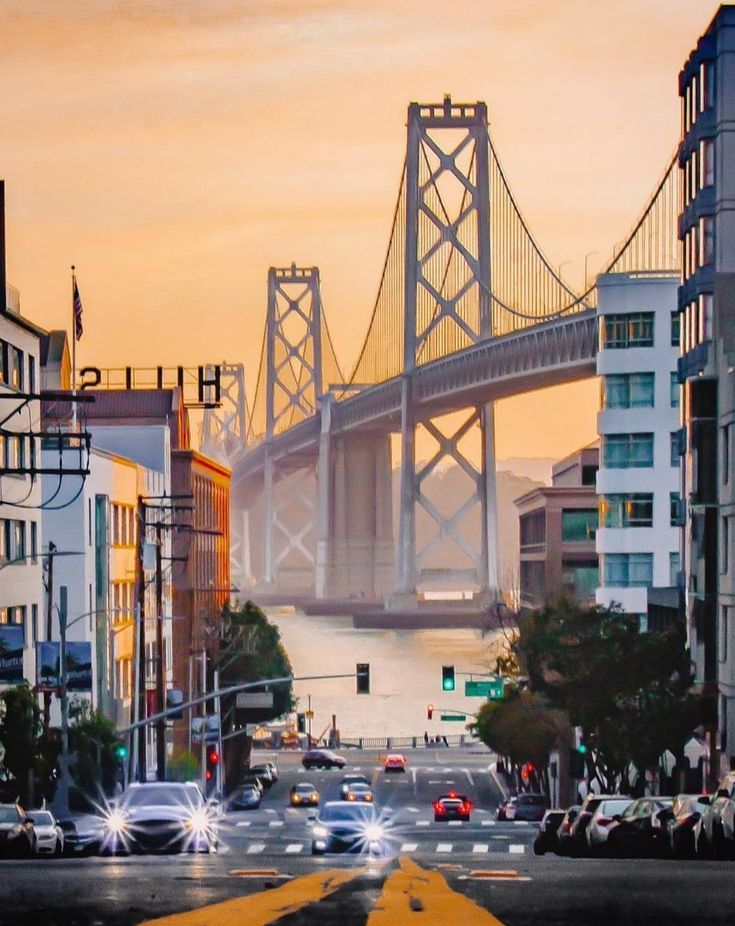 cars are driving down the street in front of a bridge