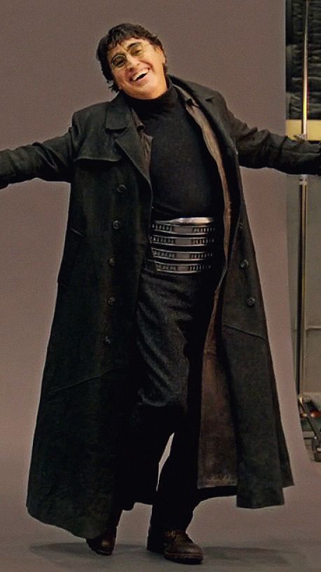 a man in a trench coat holding a large object with his arms out to the side