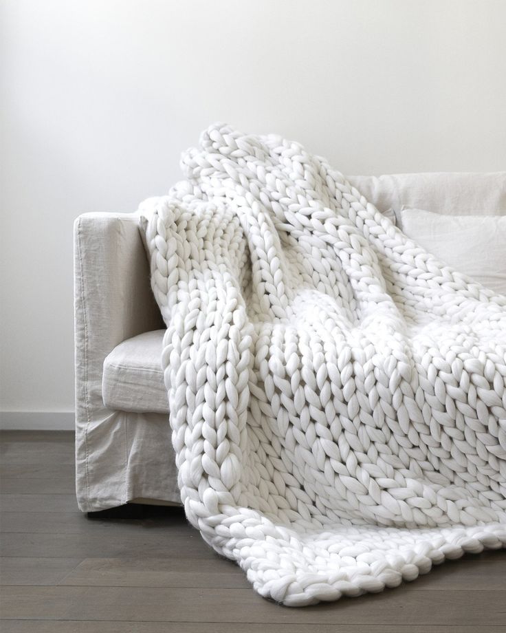 a white blanket sitting on top of a couch