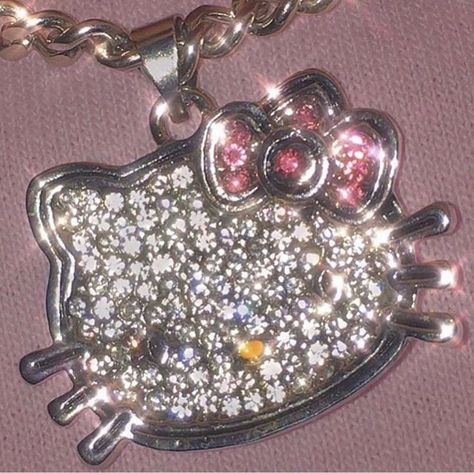 the hello kitty necklace has been decorated with swarong and sparkles on it