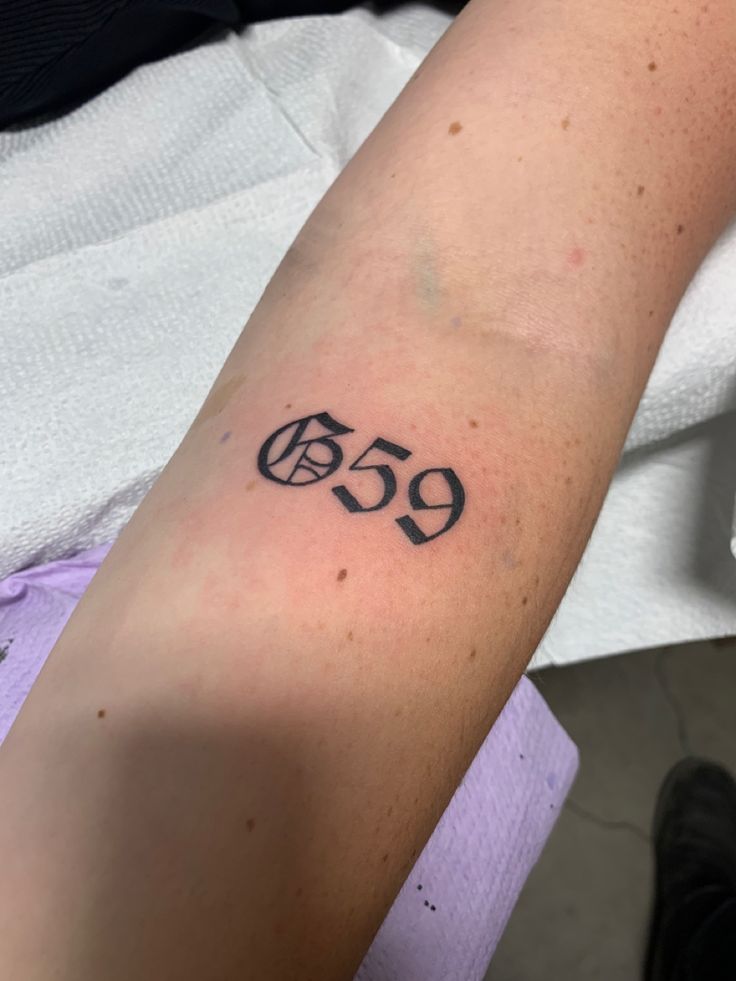 a person with a tattoo on their arm that has the number 599 in it