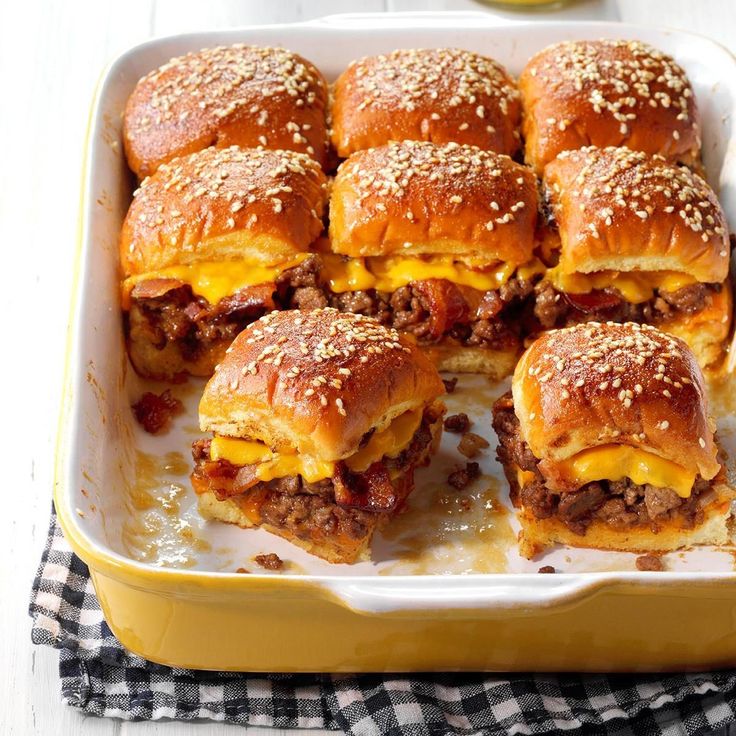 several mini sandwiches in a yellow dish on a checkered table cloth