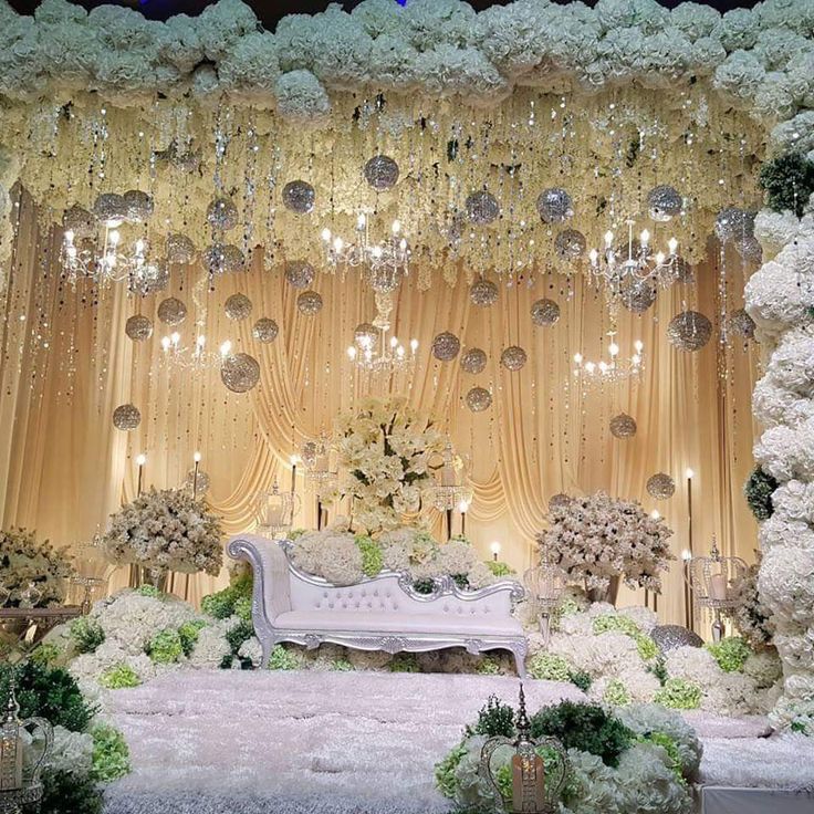 an elegant wedding stage decorated with flowers and chandeliers