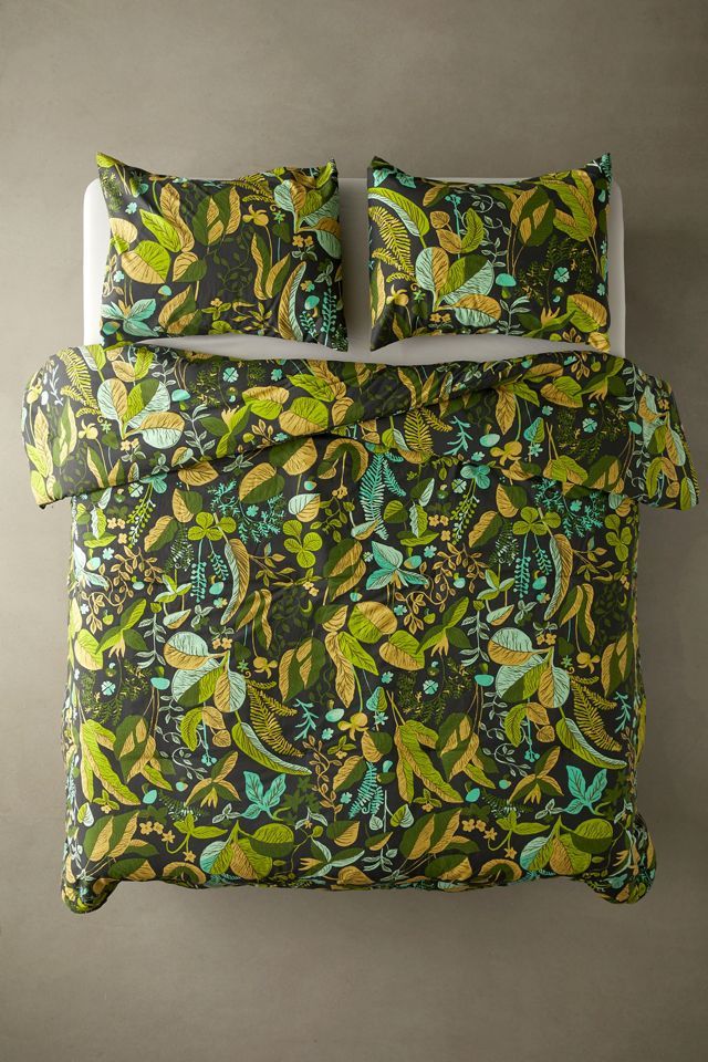 an image of a bed with green and yellow comforter set on top of it