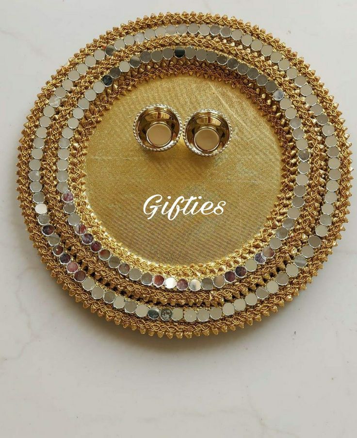 two pairs of gold plated earrings sitting on top of each other with the word gifgies written across it