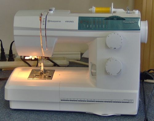 a white sewing machine sitting on top of a table