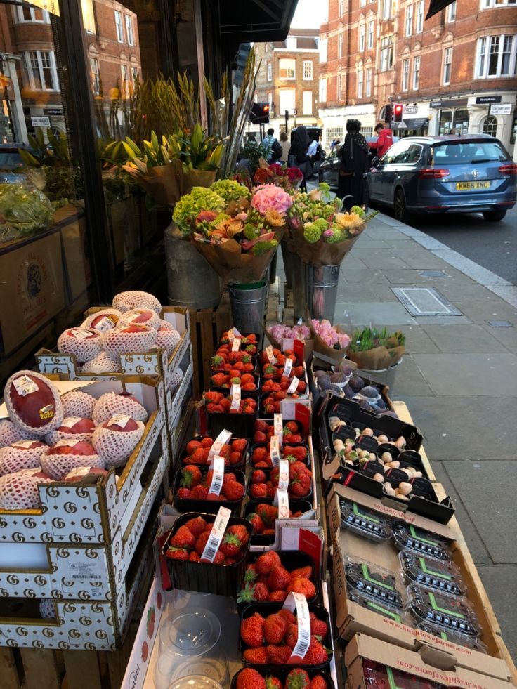 strawberries and other fruits are on display at an outdoor market