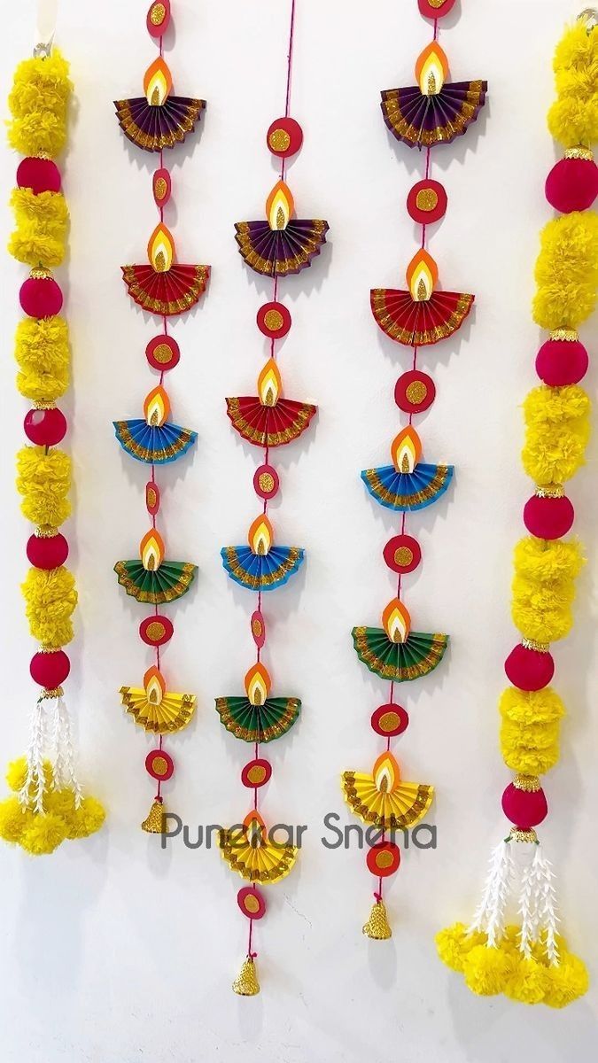 colorful garlands hanging on the wall with red, yellow and blue decorations attached to them