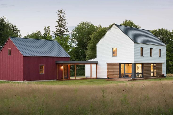 two modern houses in the middle of a grassy field