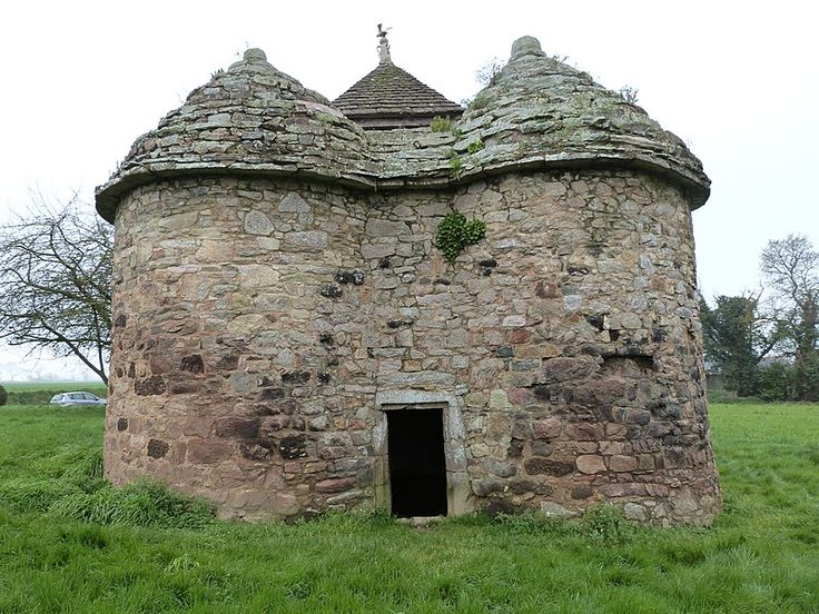 an old stone building in the middle of a field