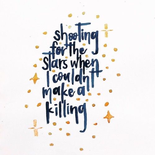 a handwritten quote on white paper with gold stars