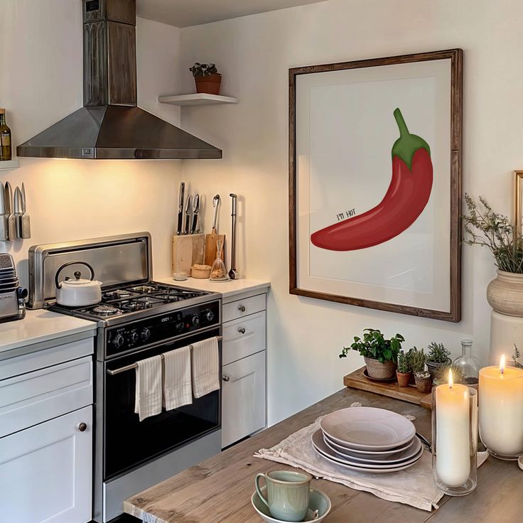 a kitchen with white cabinets and an art piece on the wall above the stove top