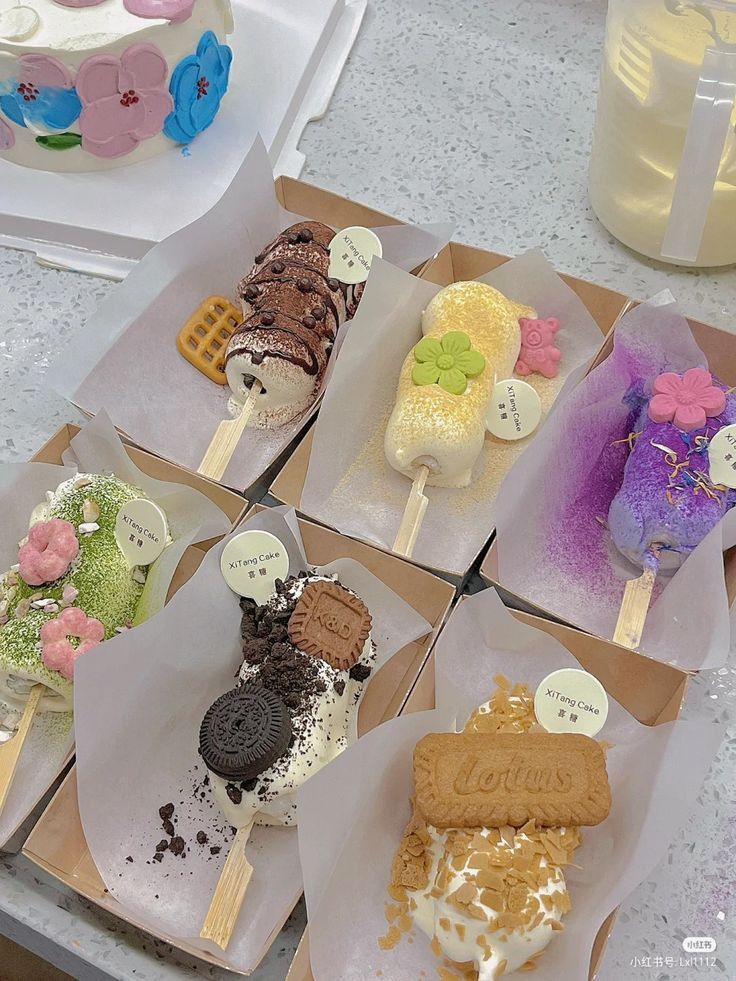 there are many different desserts in the boxes on the table with each one's own name