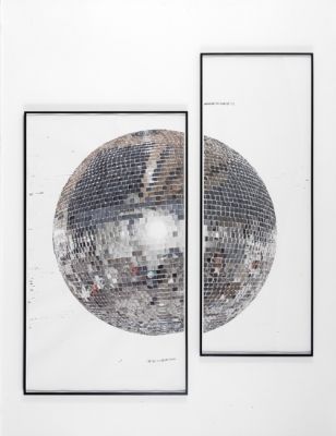 two mirrors are hanging on the wall in front of each other, with one mirror reflecting an image of a disco ball