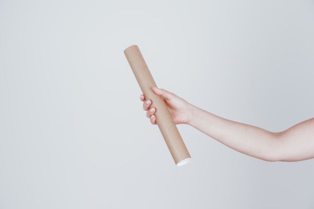 a person holding a rolled up piece of paper in their right hand with both hands