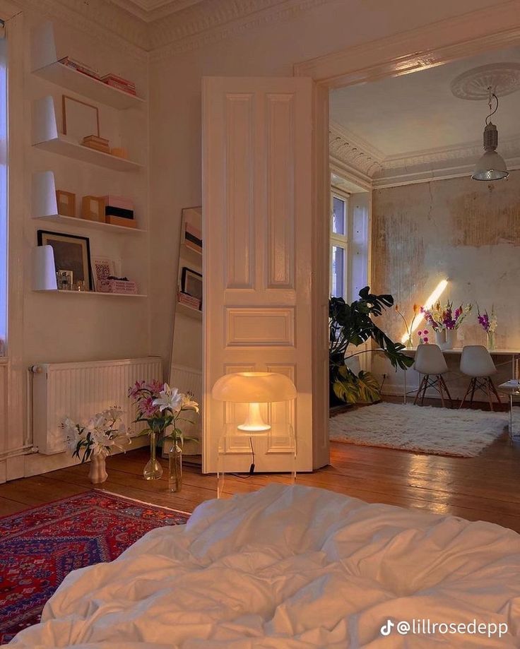 an open door leading into a bedroom with white walls and wood flooring on the other side