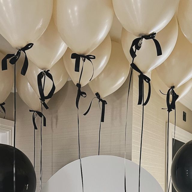 balloons are tied to the ceiling with black ribbon