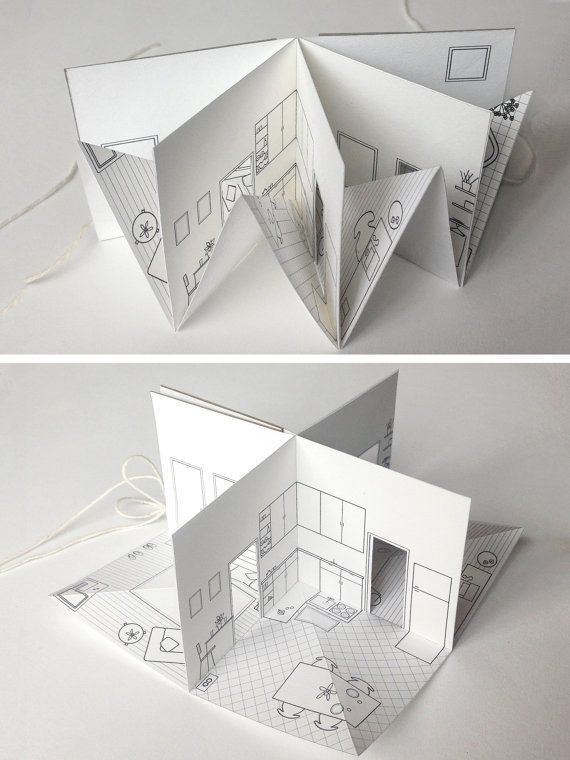 an open book with drawings on it and the inside cut out to look like a house