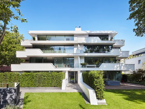 an apartment building with many balconies and plants on the lawn