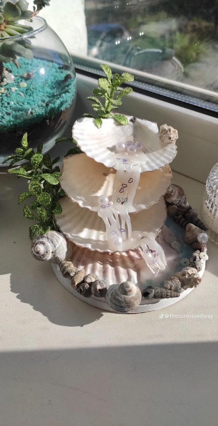 seashells are stacked on top of each other in front of a window sill