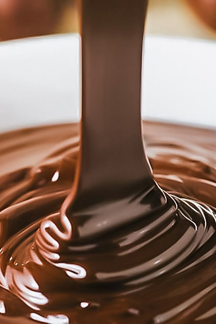 chocolate is being poured into a white bowl