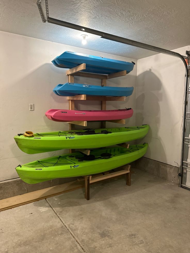 several kayaks are stacked up in a garage